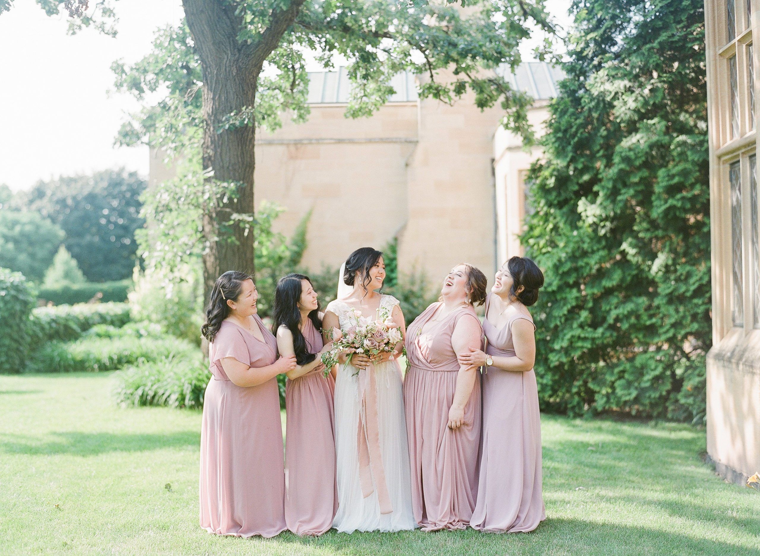 bride and bridesmaids laughing together at the paine art center