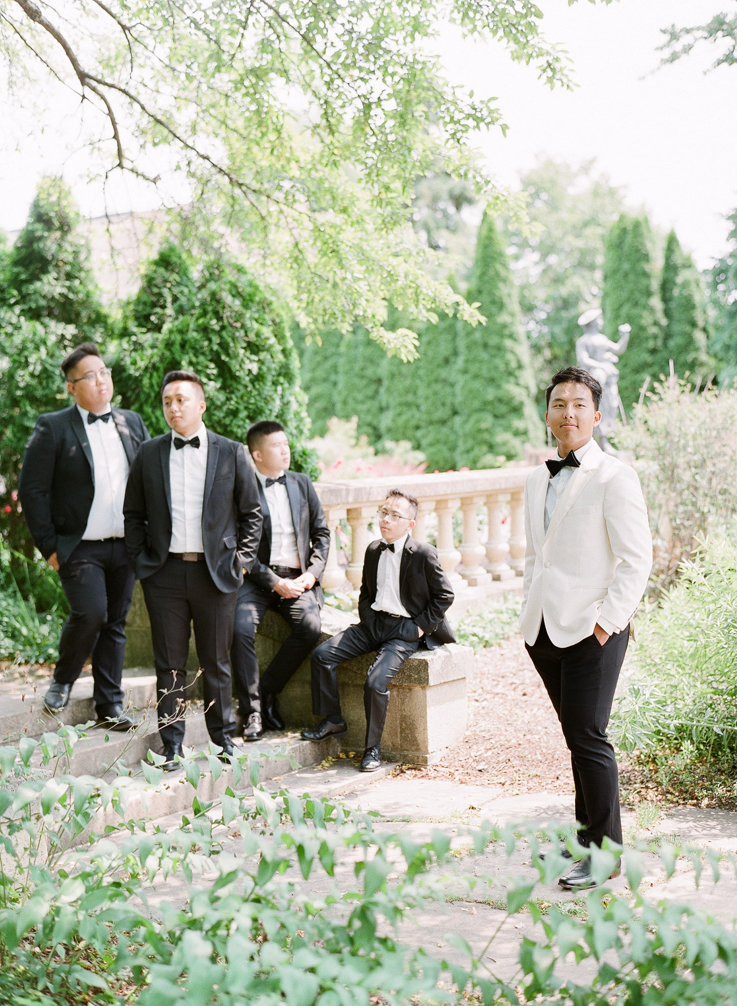 a groom and his groomsmen pose together at the paine art center