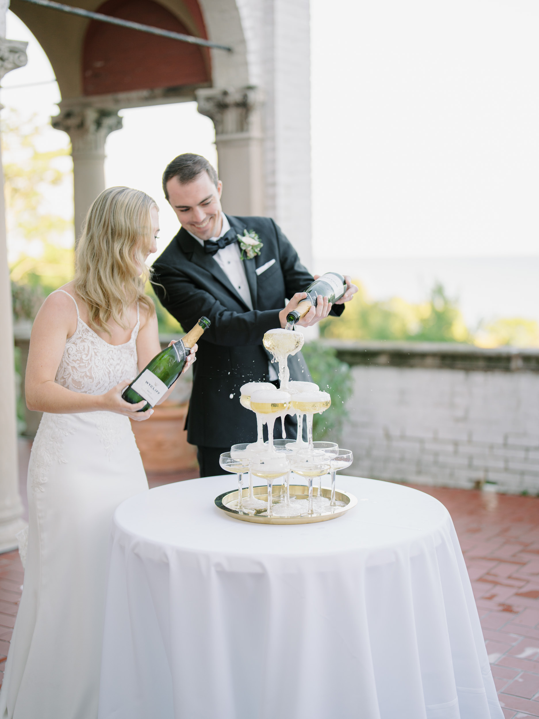 husband and wife pours into a champagne tower 